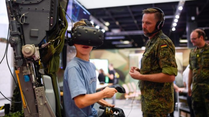 Un jeune allemand s'essayant à un simulateur de vol en réalité virtuelle lors de la Gamescon à Cologne, en Allemagne