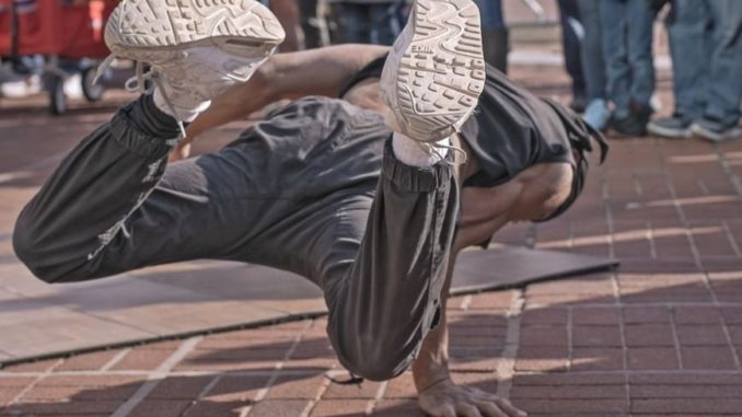 Un breackdancer executant un numéro dans la rue.